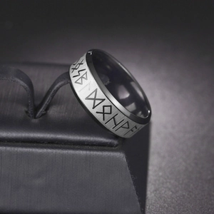 Macro detail of Nordic Runes engraved on a dual-tone black and grey stainless steel ring