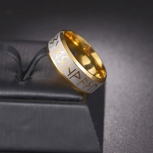 Macro detail of Nordic Viking runes on a silver matte and gold stainless steel band