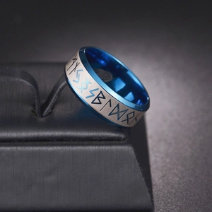 Macro detail of Nordic Viking runes on blue and silver brushed stainless steel ring