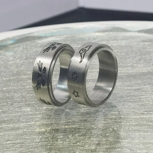 Detalle de anillos giratorios de acero cepillado con grabados de gatos y motivos celestes