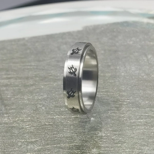 Detalle macro del anillo giratorio antiestrés de acero inoxidable con grabados de tortugas