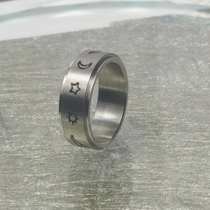 Detalle de anillo giratorio de acero inoxidable con grabados de sol, luna y estrellas