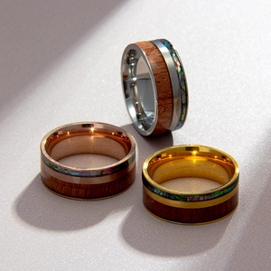 Macro shot of titanium steel rings with wood inlay and iridescent shell patterns