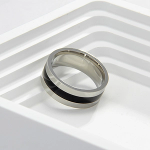 Detailed macro view of the two-tone black enamel inlay on a polished stainless steel ring