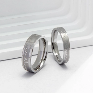 Polished stainless steel couple rings featuring electrocardiogram and heart engraving