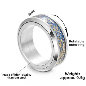 Detail of 8mm rotating titanium steel ring featuring blue gold celtic dragon inlay