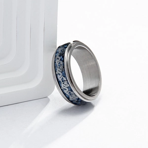 Macro shot of titanium steel ring with blue carbon fiber inlay and silver dragon pattern