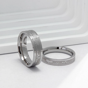 Close-up of polished silver titanium steel rings with engraved heart rate EKG pulse patterns
