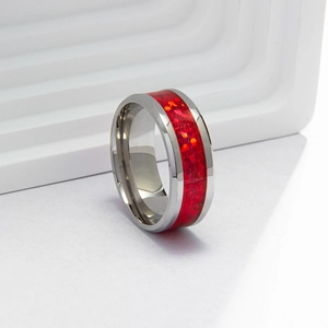 Macro shot of silver stainless steel ring with red synthetic opal inlay on white stand