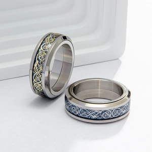 Rotating stainless steel spinner ring with blue carbon fiber and Celtic dragon pattern inlay