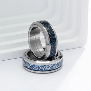 Close-up of blue carbon fiber inlay and celtic dragon pattern on wide steel ring band