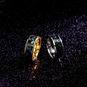 Close-up of gold and silver titanium rings with colorful opal inlay and mirror finish