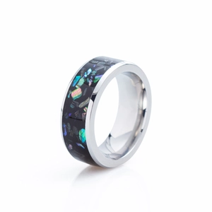Macro detail of 8mm galaxy opal inlay and polished titanium steel ring surface