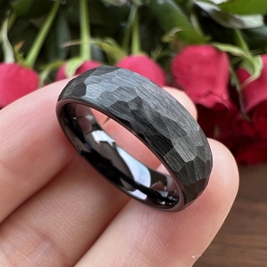 Vue rapprochée d'une bague noire martelée de 8mm avec intérieur poli sur une rose rouge