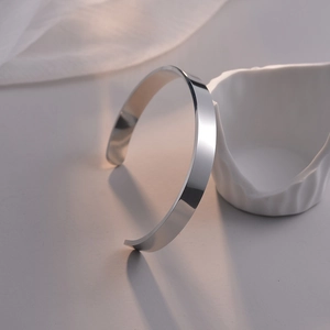 Detailansicht eines minimalistischen silbernen Edelstahl-Armreifs mit polierter Oberfläche