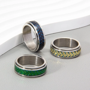 Spinner ring set in stainless steel with leaf patterns and carbon fiber textures