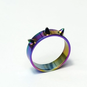 Dettaglio macro di un anello arcobaleno in acciaio inossidabile con tre punte stile punk