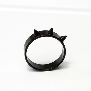 Dettaglio di un anello punk gotico nero con tre punte in acciaio inossidabile opaco