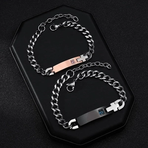 Détail de bracelets de couple avec pendentif croix et cristal sur maillons cubains