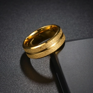 Dettaglio macro dell'anello dorato 8mm con superficie satinata e scanalatura lucida