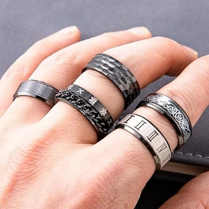 Macro detail of 5-piece stainless steel spinner rings for men featuring roman numerals