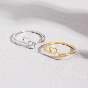Macro detail of intertwined heart-shaped rings in gold and silver metallic finishes