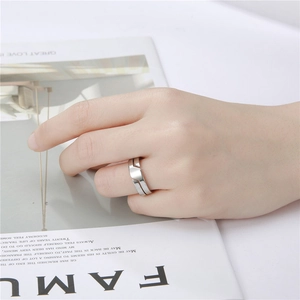 Detailed close-up of a silver geometric split ring showcased on a finger against a magazine