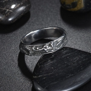 Close-up of vintage silver dragon ring with detailed 3D carving on black stones