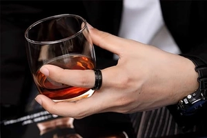 Gros plan d'une bague rotative pour homme en métal noir brossé mat dans un cadre de luxe