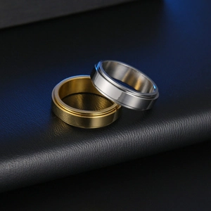 Detail of 6mm minimalist spinning rings in gold and silver finish on leather