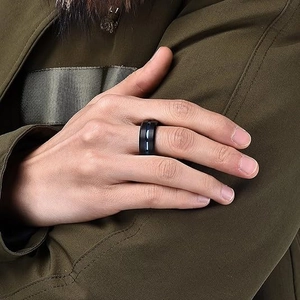 Détail d'une bague noire mate pour homme avec incrustation bleue portée sur le doigt