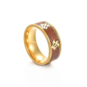 Détail d'un motif de tortue gravé sur un insert en bois d'acacia dans une bague dorée
