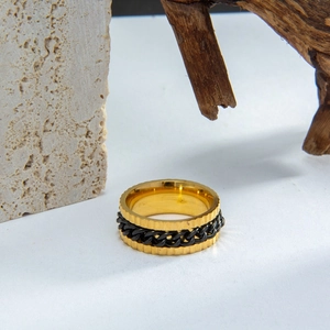 Detail shot of men's gear ring featuring a black Cuban chain on golden stainless steel