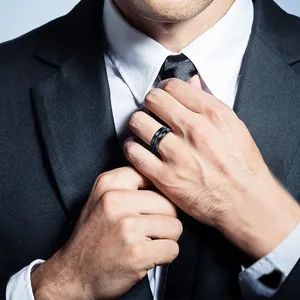 Close-up of matte black steel ring with blue inlay on a male model in professional suit