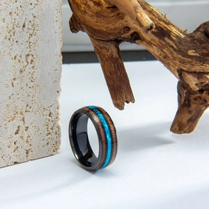 Detail view of wood inlay ring with vibrant blue crushed opal on a black metal band