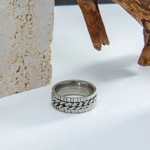 Macro detail of industrial rotatable chain ring with gear textured edges in silver finish