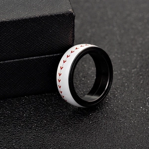 Gros plan sur la bague rotative thème baseball avec coutures rouges sur métal blanc