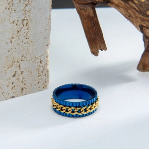 Blue stainless steel gear ring with gold rotatable chain inlay on rustic wood base