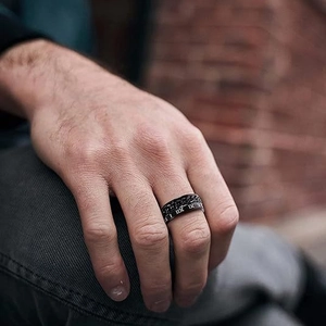 Men's black stainless steel ring with Cuban chain and Roman numeral engraving worn on hand