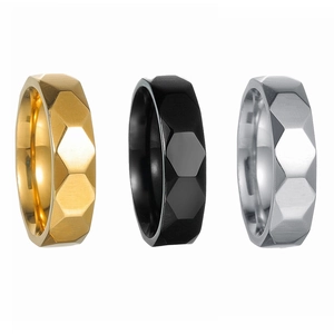 Macro detail of honeycomb geometric rings in gold, black, and silver brushed stainless steel