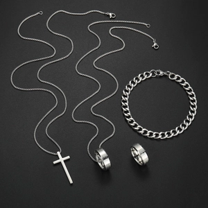 Detailed view of silver cross pendant necklace and engraved religious band ring set