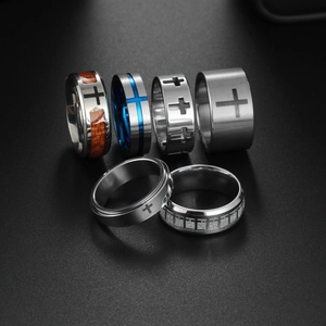 Macro shot of titanium steel rings set featuring cross motifs and blue brushed finishes