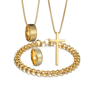 Detail of gold religious jewelry set featuring cross necklace and engraved Jesus ring