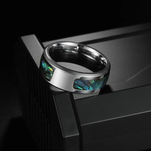 Polished silver titanium ring with iridescent abalone shell inlay on black background