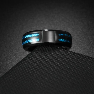 Primer plano de un anillo negro pulido para hombre con incrustación de ópalo azul