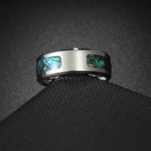 Macro shot of men's titanium ring with colorful abalone shell inlay and brushed metal finish