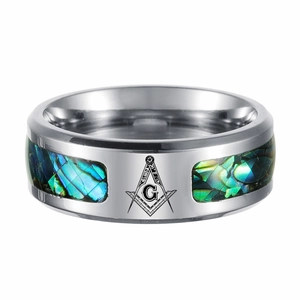 Detailed close-up of polished silver ring with abalone shell inlays and compass emblem