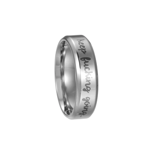 Macro detail of silver titanium steel ring featuring keep fucking going engraving