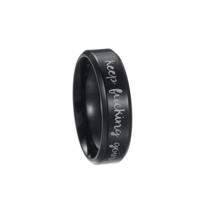 Detail of matte black stainless steel ring with laser engraved motivational quote text