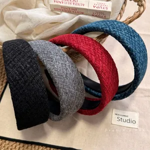 Cerchietti larghi in tweed stile francese in quattro colori su un cesto intrecciato